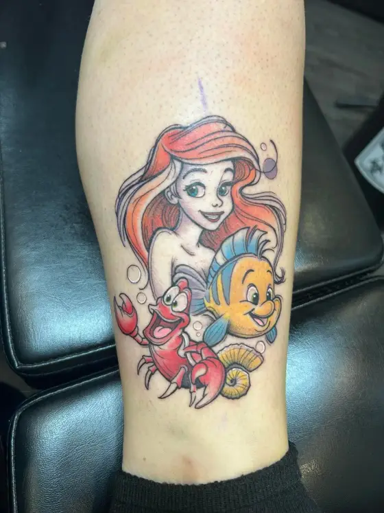 Tatouage couleur d'Ariel, Sébastien et Polochon sur un mollet.